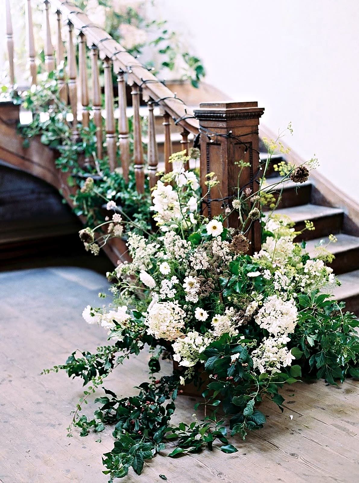White blooms and trailing greenery along a staircase